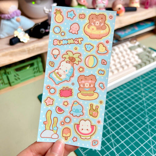 Sheet of colorful stickers with summer-themed designs held over a desk.