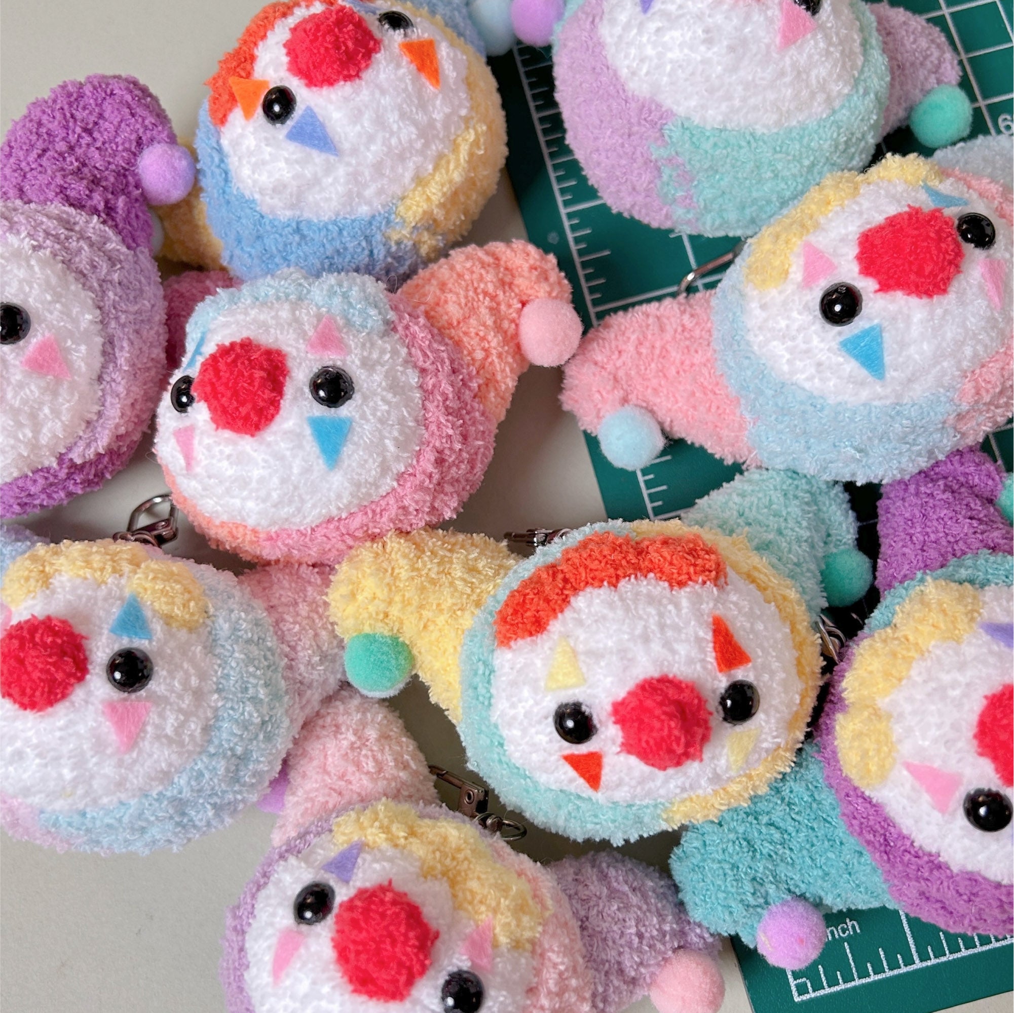 Colorful plush keychains with cartoon faces on a white background