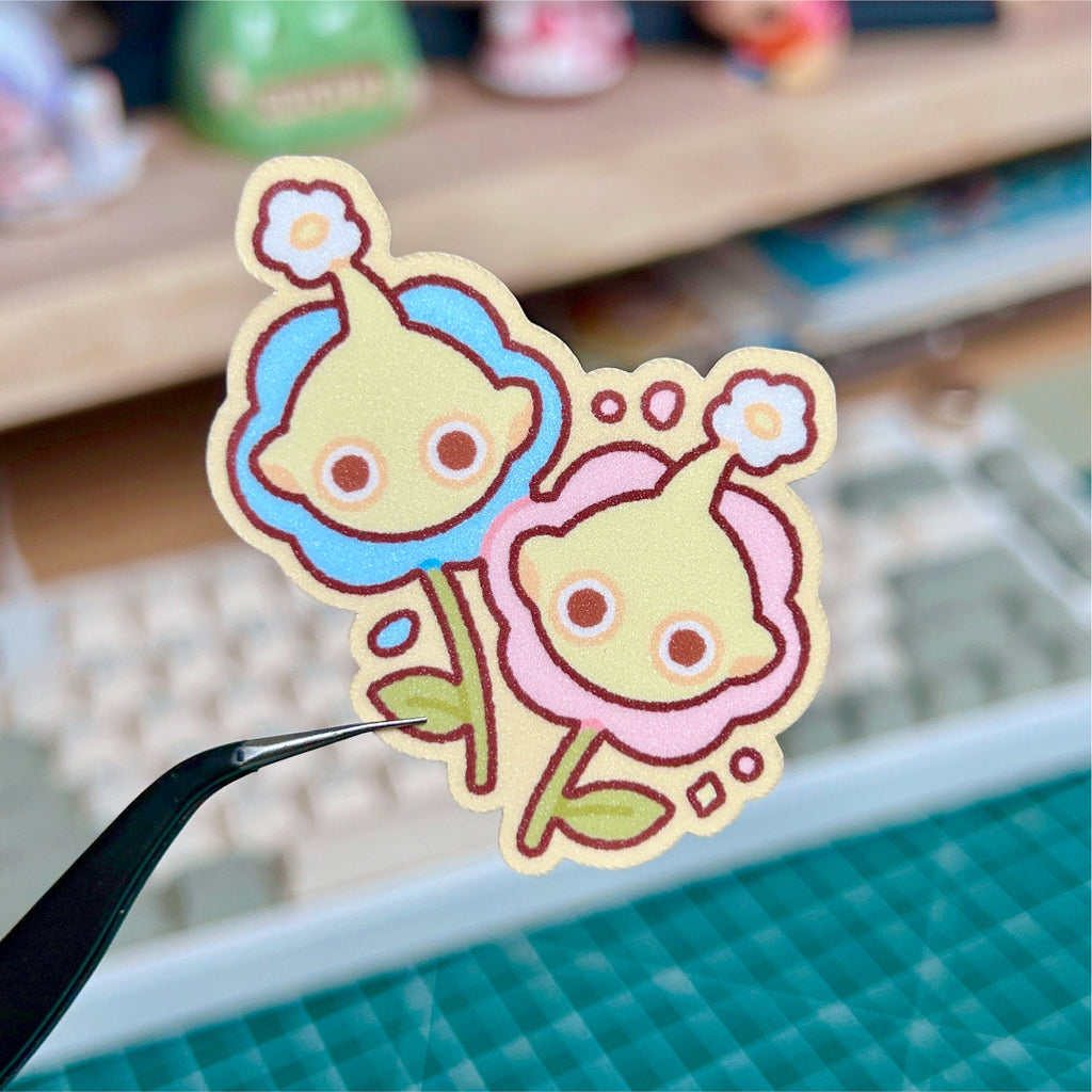Cartoon character sticker held by a hand with a blurred background