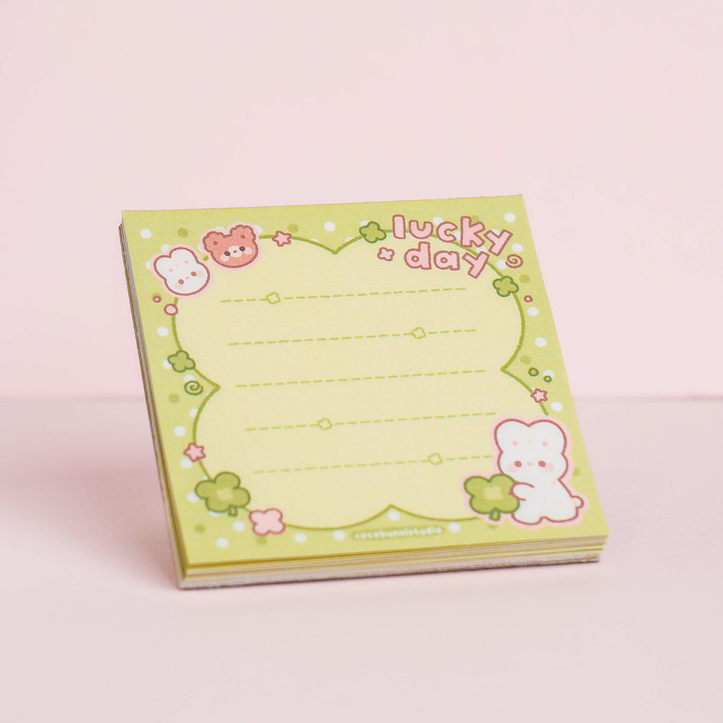 Notebook with characters and 'lucky day' text on a pink background
