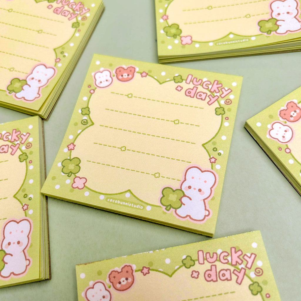 Set of small memopads with bear and bunny illustrations and 'lucky day' text on a light green background