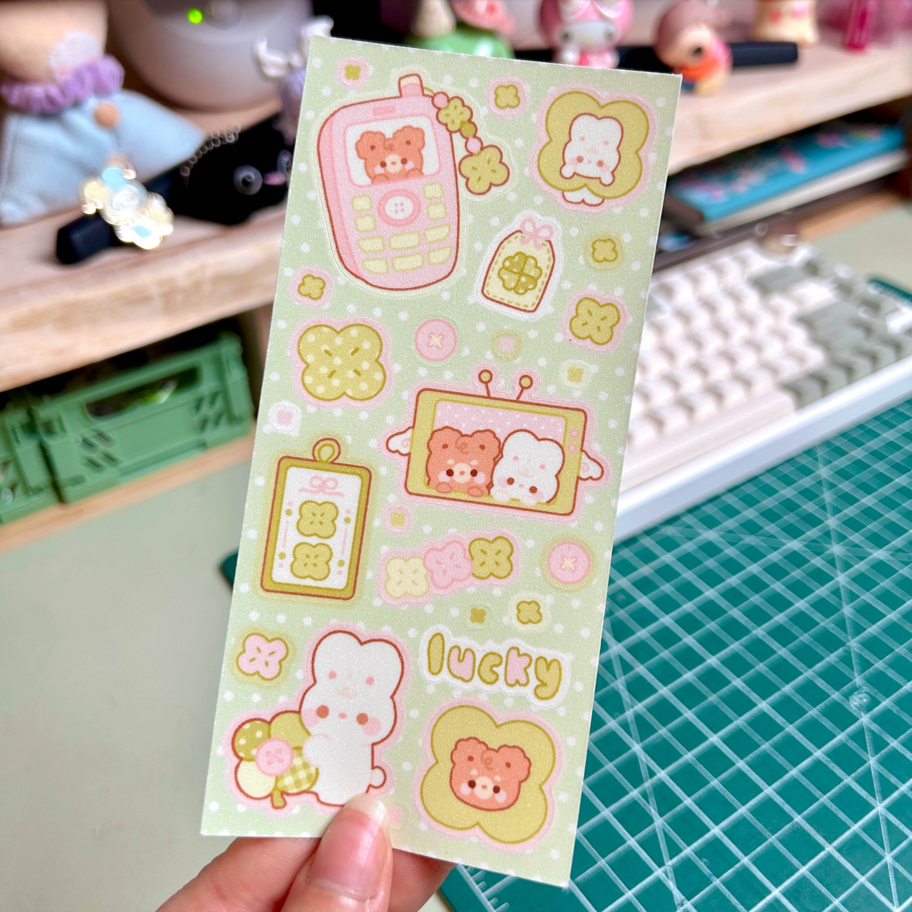 Sheet of cute stickers with cartoon characters held over a desk.