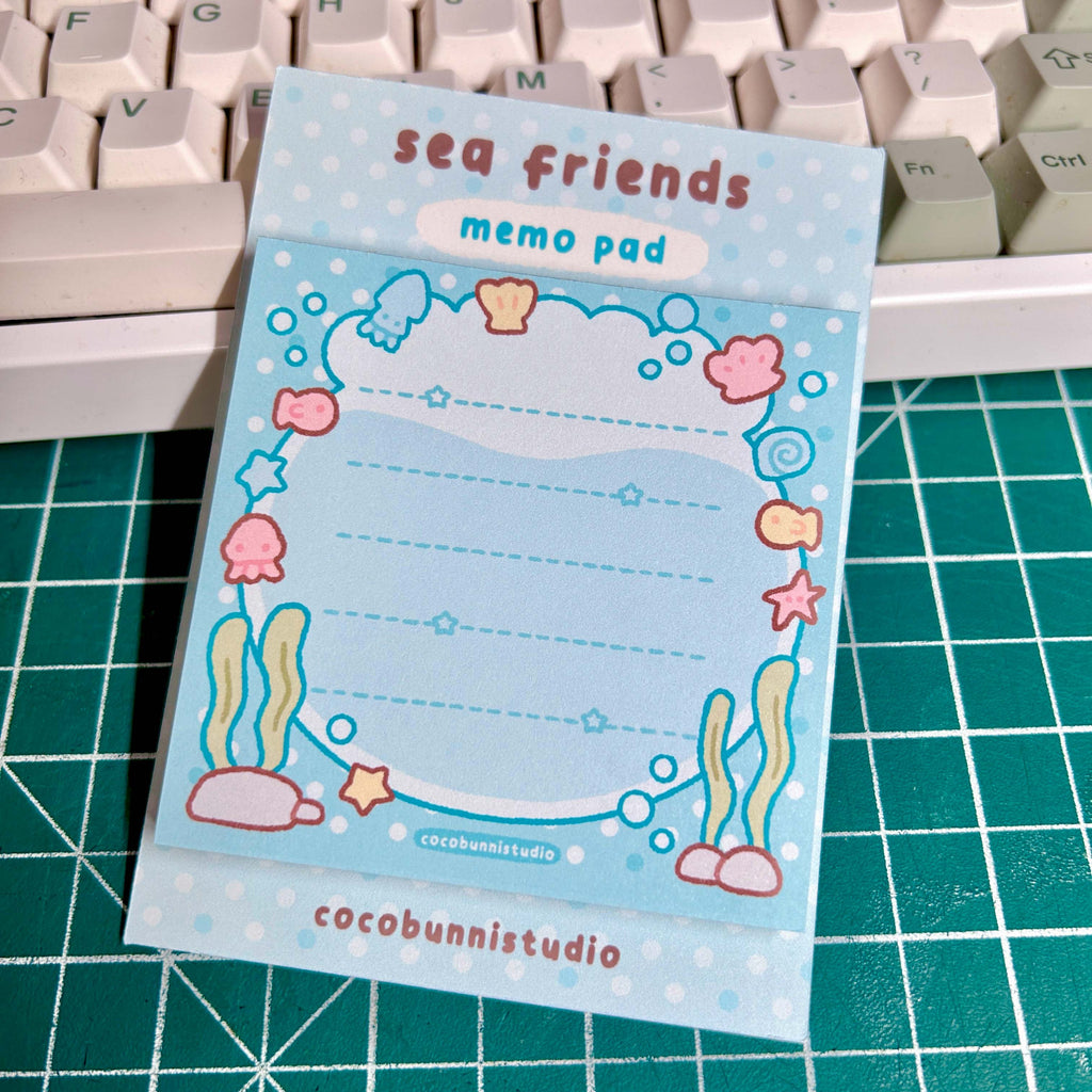 Memo pad with sea-themed design on a cutting mat with keyboard in the background