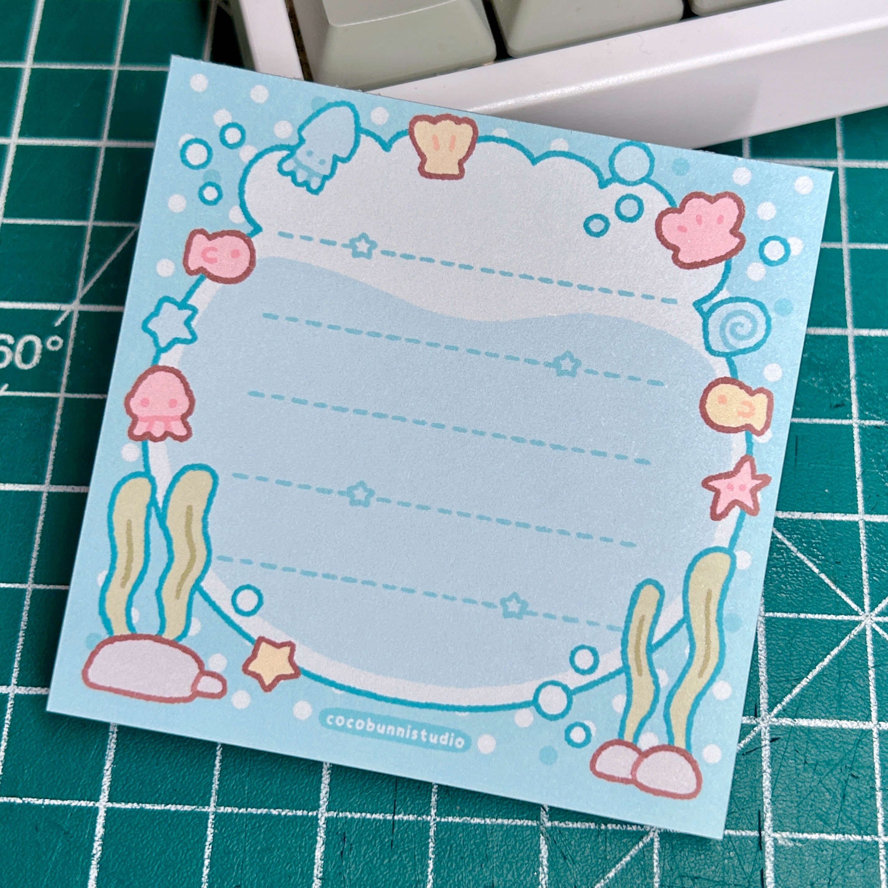 Notepad with underwater design on a green grid surface
